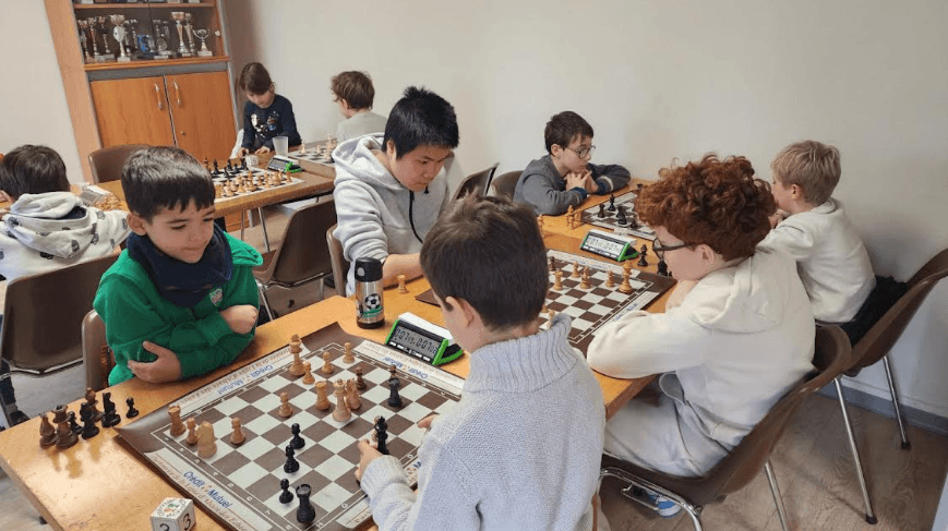 Jeunes joueurs réunis autour des échiquiers au club Colmar Échecs